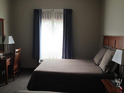 Pleasant Night Inn- carthage NY في West Carthage: غرفة نوم بسرير ونافذة مع ستائر