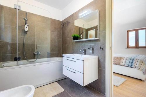ein Bad mit einer Badewanne, einem Waschbecken und einer Dusche in der Unterkunft Villa Marron in Veprinac