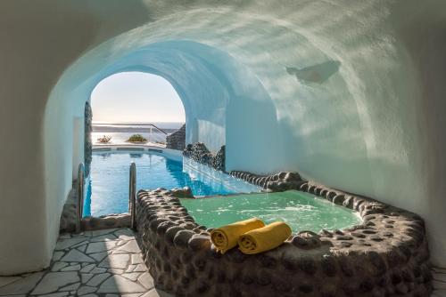 a swimming pool in a building with a water park at Fanari Villas in Oia