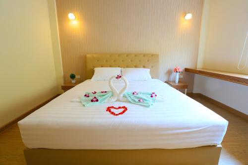 a bedroom with a white bed with two hearts on it at Venice Resort in Ban Sai Mai