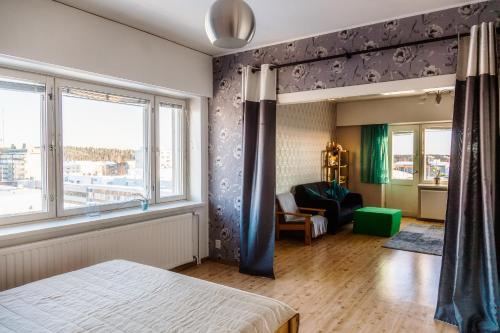 a bedroom with a bed and a couch and a window at Kouvola Apartment in Kouvola