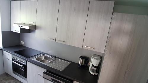 a kitchen with a sink and a stove and cabinets at Haus Christof in Holzgau