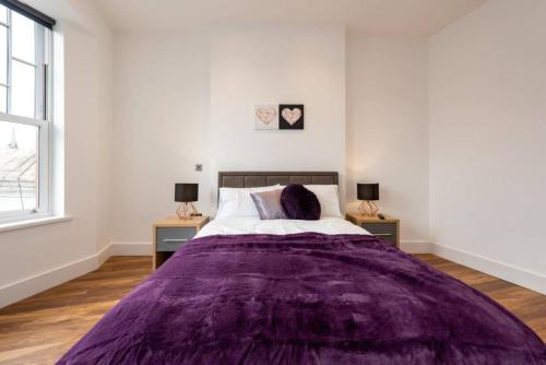 um quarto branco com um cobertor roxo numa cama em Spacious and Luxurious London Apartment (MHB352) em Londres