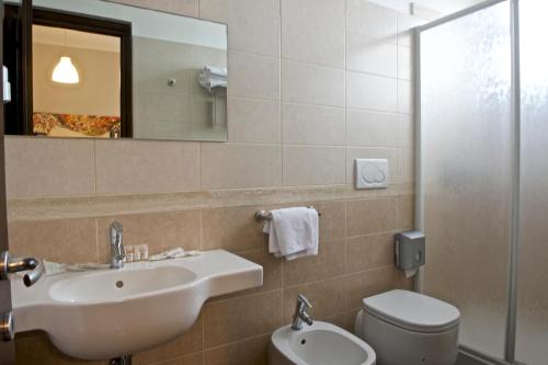 a bathroom with a sink, toilet and mirror at Hotel Ristorante Centosedici in Terracina