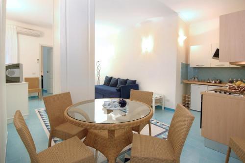 a kitchen and a living room with a table and chairs at Aurora Apartments in Amalfi