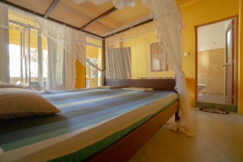 a bedroom with a large bed with a canopy at Praneeth Guest House in Mirissa