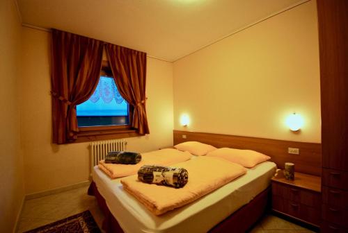 een slaapkamer met een bed met twee camera's erop bij Appartamenti Sport 3000 in Livigno