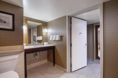 a bathroom with a toilet and a sink and a mirror at Red Deer Resort & Casino in Red Deer
