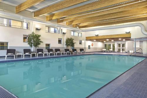 a large swimming pool in a hotel room with chairs at Red Deer Resort & Casino in Red Deer