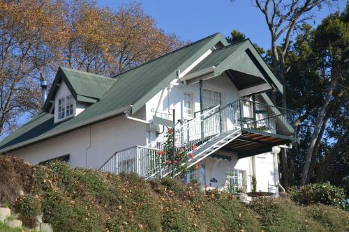 une maison blanche avec un toit vert dans l'établissement Gateside Guesthouse, à Hilton