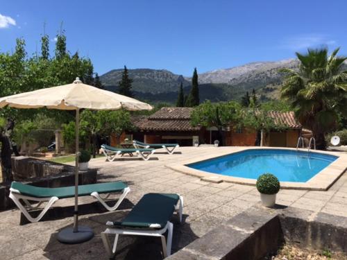 a pool with two lounge chairs and an umbrella at Finca CAN TRUI teresa in Pollença