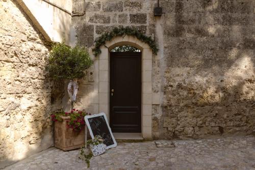 a black door with a chalkboard in front of a building at Antica Torre di Iuso in Matera
