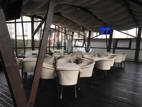 a group of tables and chairs in a restaurant at Ambiance Hotel in Bucharest