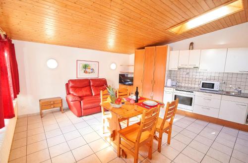 eine Küche mit einem Tisch und einem roten Sofa in der Unterkunft Residence Jungfrau in Interlaken