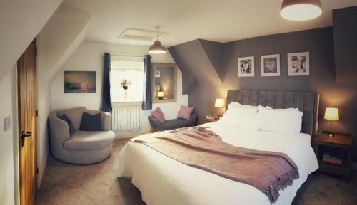 1 dormitorio con 1 cama grande y 1 silla en The Loft at Peake’s retreats en Needwood