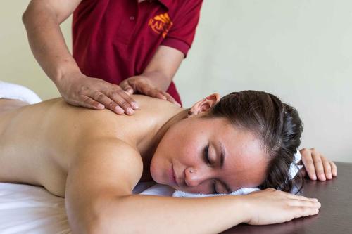 a woman getting a massage from a therapist at Rakkh Resort, a member of Radisson Individuals Retreats in Pālampur