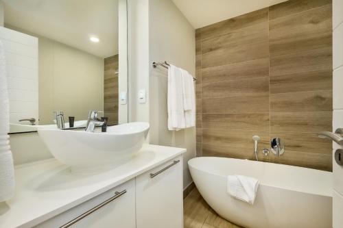 y baño con lavabo blanco y bañera. en The Regency Apartment Hotel Menlyn, en Pretoria