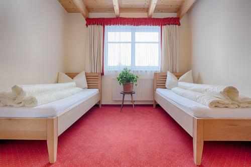 zwei Betten in einem Zimmer mit Fenster in der Unterkunft Appartement Klostertal in Innerbraz