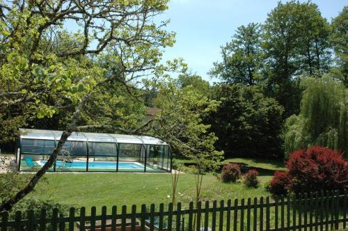 a bus parked in a yard with a fence at La Palombiere in Lucmau