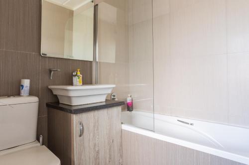 Un baño con lavabo, inodoro y bañera. en Alimama Spaces: Manson's Bedford Haven, en Johannesburgo
