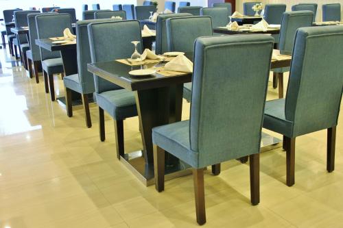 a row of tables and chairs in a restaurant at Carawan Al Fahad Hotel in Riyadh