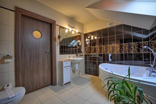 łazienka z wanną, toaletą i umywalką w obiekcie Pensjonat Szajna Spa w Rymanowie-Zdroju