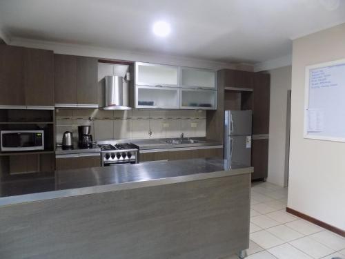 a large kitchen with a stainless steel counter top at Las Arecas - rucci 61 in Puerto Iguazú