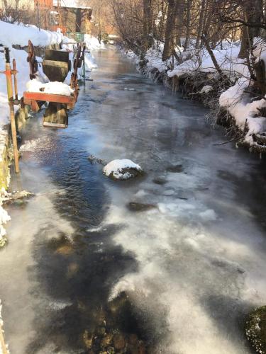 a river with snow on the sides of it at Privát Erika in Liptovský Ján