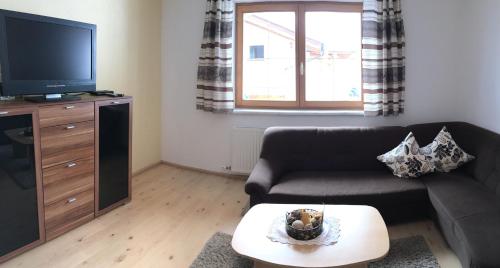 a living room with a couch and a tv at Ferienwohnung Halder in Neustift im Stubaital