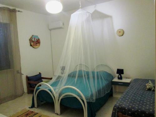 タヴィアーノにあるCasa in macchia mediterraneaのベッドルーム(蚊帳付きのベッド付)