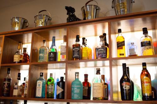 a shelf filled with lots of bottles of alcohol at Hartnoll Hotel & Spa in Tiverton