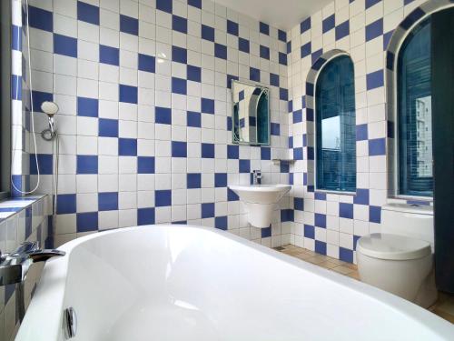 a bathroom with a tub and a toilet and a sink at Kenting True Color Hostel in Hengchun