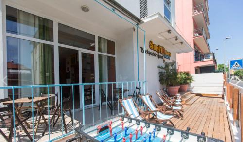 a balcony of a building with chairs and a pool at Sunflower Beach Backpacker Hostel & Bar in Rimini