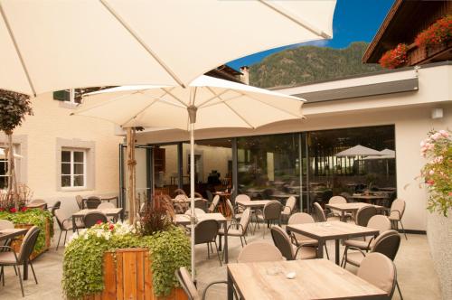 an outdoor restaurant with tables and chairs and umbrellas at Luxury Lodge - Lener Express in Campo di Trens