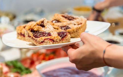 a person holding a plate with a piece of dessert at Luxury Lodge - Lener Express in Campo di Trens