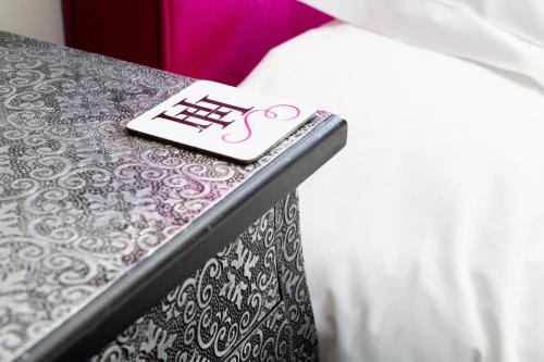 a remote control sitting on a table next to a bed at Hartnoll Hotel & Spa in Tiverton