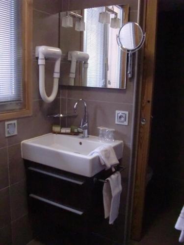 a bathroom with a sink and a mirror at Aiguille du Midi - Hôtel & Restaurant in Chamonix-Mont-Blanc