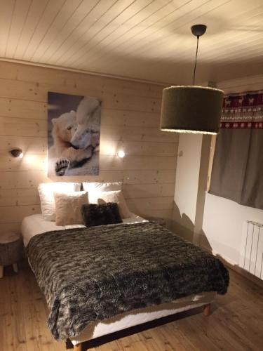 une chambre avec un lit dans un mur en bois dans l'établissement L'Appart de l'Arche, à Peisey-Nancroix