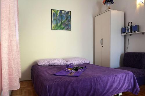 Apartment Ravni 1337 في رافني: غرفة نوم مع سرير أرجواني مع بطانية أرجوانية