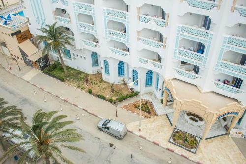 an apartment building with a car parked in front of it at Hotel Dreams Beach in Hammam Sousse