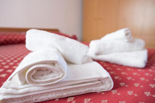 a pile of towels sitting on top of a bed at Residence Capo San Marco & Renella in Sciacca