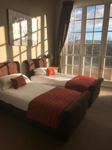 two beds in a hotel room with windows at The Spa Hotel in Saltburn-by-the-Sea
