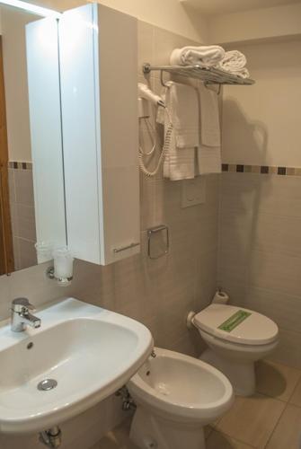 a bathroom with a white sink and a toilet at Hotel Italia in Sacile