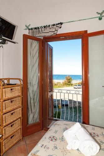 a room with a sliding glass door with a view of the ocean at Stella Marina Budoni in Budoni