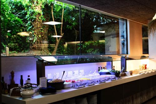 a buffet line with dishes and bottles of food at Hotel Vista Odin in Playa de Palma