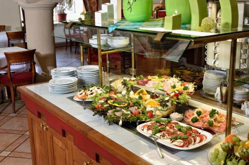 a buffet with many plates of food on a counter at Hotel Graf von Mansfeld in Lutherstadt Eisleben