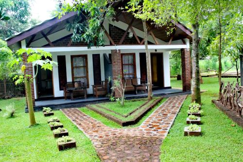 a house with a stone walkway in front of it at Green Cottage in Anuradhapura