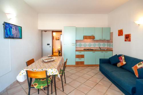 a living room with a table and a blue couch at Stella Marina Budoni in Budoni