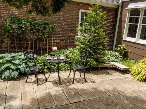 a patio with two chairs and a table with flowers at Culverdene House in Simcoe