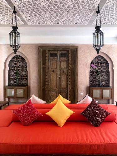 a red couch with colorful pillows in a room at The Ryad Rayong in Mae Pim